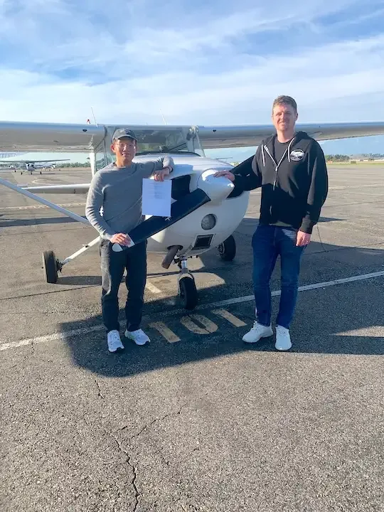 Examiner congratulating a student pilot after a successful FAA checkride at Riverside Municipal Airport